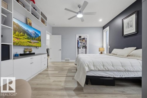 Wood-finish flooring, built-in shelving, ceiling fan, recessed lighting, and a walk-in closet with built-in organizers - 3303 Soleil Boulevard, Beaumont, AB - Indoor Photo Showing Bedroom