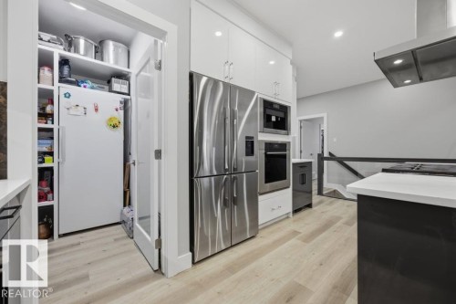 Gourmet kitchen with stainless steel appliances, built-in oven, integrated microwave, and a separate pantry with custom shelving - 3303 Soleil Boulevard, Beaumont, AB - Indoor Photo Showing Kitchen