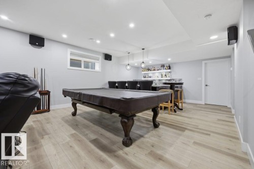 Wood-finish flooring, recessed lighting, and a built-in wet bar with a tiled backsplash - 3303 Soleil Boulevard, Beaumont, AB - Indoor Photo Showing Other Room