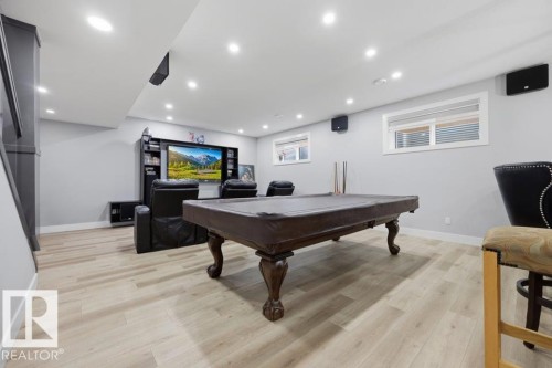 Recessed lighting, wood-finish flooring, two windows, and a built-in entertainment center - 3303 Soleil Boulevard, Beaumont, AB - Indoor Photo Showing Other Room