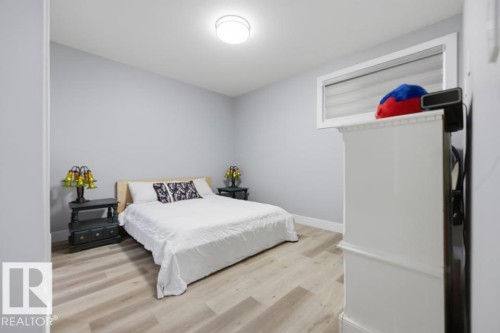 Light wood-finish flooring, white baseboards, and a flush-mount ceiling light - 3303 Soleil Boulevard, Beaumont, AB - Indoor Photo Showing Bedroom