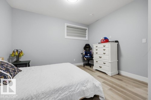 Recessed ceiling light, light-toned walls, wood-finish flooring, and white trim - 3303 Soleil Boulevard, Beaumont, AB - Indoor Photo Showing Bedroom