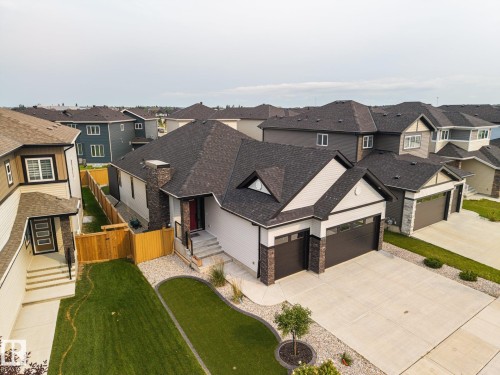 Modern exterior with stone accents, attached two-car garage, concrete driveway, and manicured landscaping - 3303 Soleil Boulevard, Beaumont, AB - Outdoor