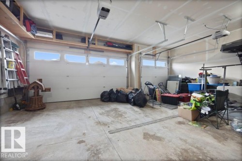 Concrete flooring and a dual overhead garage door system - 3303 Soleil Boulevard, Beaumont, AB - Indoor Photo Showing Garage