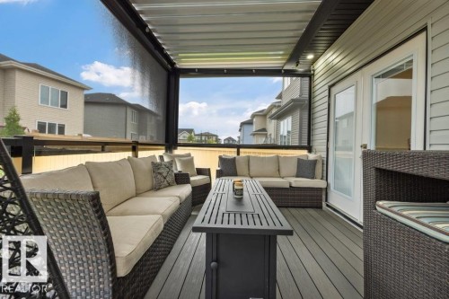 Covered deck featuring composite decking, a clear panel railing, and integrated overhead lighting - 3303 Soleil Boulevard, Beaumont, AB - Outdoor With Deck Patio Veranda With Exterior