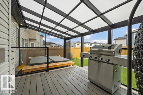 Covered deck with composite decking, transparent roof, and glass panel railing - 3303 Soleil Boulevard, Beaumont, AB - Outdoor With Deck Patio Veranda With Exterior