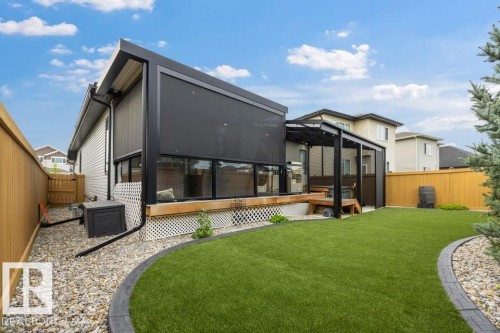 Expansive backyard featuring a manicured lawn, a gravel border, and a wood deck with a covered pergola - 3303 Soleil Boulevard, Beaumont, AB - Outdoor With Deck Patio Veranda