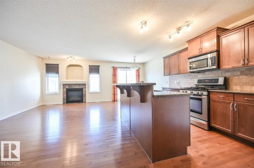 11425 14 Avenue Sw, Edmonton, AB - Indoor Photo Showing Kitchen With Fireplace With Stainless Steel Kitchen