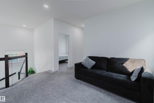 Carpeted hallway with recessed lighting and a wood-finish and glass railing - 5320 Kimball Place Sw, Edmonton, AB - Indoor