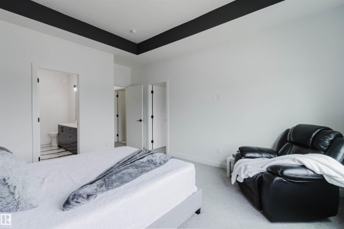 High ceilings with a dark accent beam, light-colored carpeting, white walls, and white interior doors with dark hardware - 5320 Kimball Place Sw, Edmonton, AB - Indoor