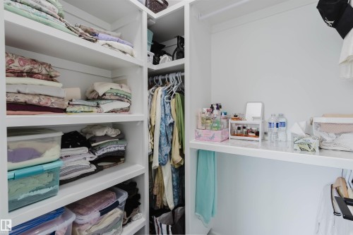 Built-in shelving, integrated closet rod, and white wall finishes - 5320 Kimball Place Sw, Edmonton, AB - Indoor With Storage