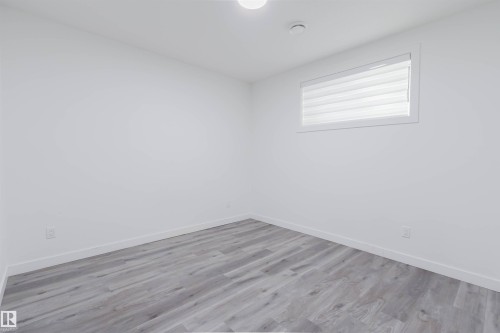 Recessed lighting illuminates wood-finish flooring in this room featuring a window with privacy blinds - 5320 Kimball Place Sw, Edmonton, AB - Indoor Photo Showing Other Room
