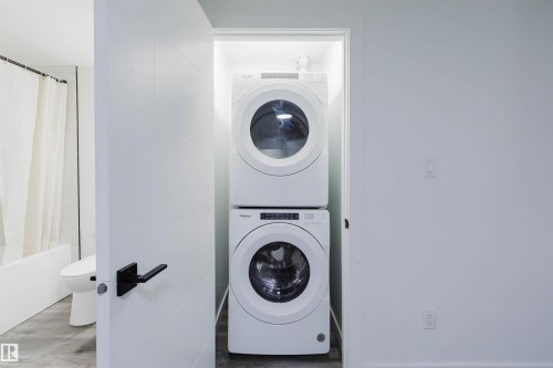 Integrated stacked washer and dryer within a dedicated utility closet - 5320 Kimball Place Sw, Edmonton, AB - Indoor Photo Showing Laundry Room