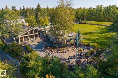 Vaulted ceilings with expansive glass, exterior patio, terraced landscaping, large grassy area, and mature trees - 139 Silver Beach Road, Rural Wetaskiwin County, AB - Outdoor With View