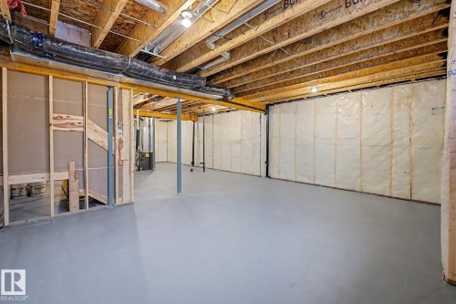 Unfinished basement featuring exposed wood joists, structural support beams, and partially insulated walls - 5435 Hawthorn Run Sw, Edmonton, AB - Indoor Photo Showing Basement