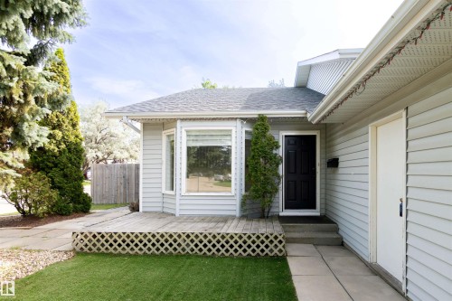 Front exterior featuring light gray siding, a dark gray shingle roof, and a welcoming porch area - 4903 11A Avenue Nw, Edmonton, AB - Outdoor With Exterior