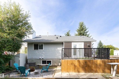 Rear exterior featuring a wooden deck with black metal railings, light grey horizontal siding, and a brown horizontal siding accent - 4903 11A Avenue Nw, Edmonton, AB - Outdoor With Deck Patio Veranda With Exterior