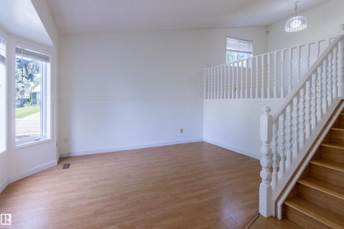 Light wood-finish flooring with a white trim baseboard - 4903 11A Avenue Nw, Edmonton, AB - Indoor Photo Showing Other Room
