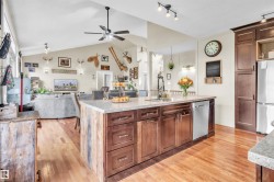 Kitchen island with a granite-style countertop, undermount sink, and integrated stainless steel dishwasher - 
