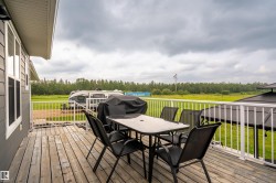 Spacious outdoor deck with wood-finish flooring and white railing - 