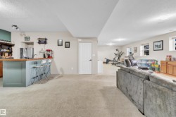 Spacious finished basement with light-colored carpeting, recessed lighting, and multiple windows - 