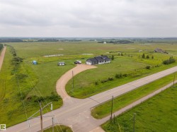 Expansive property featuring a single-story residence with a covered porch and dark gray siding - 