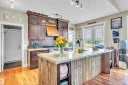 Kitchen featuring rich wood cabinetry, stainless steel appliances, and a wood-finish floor - 