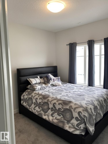 Plush carpeting, bright white walls, and a contemporary ceiling light fixture - #3 2905 141 St Sw, Edmonton, AB - Indoor Photo Showing Bedroom