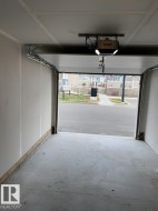 Attached garage with concrete flooring, automatic garage door opener, and integrated lighting - 