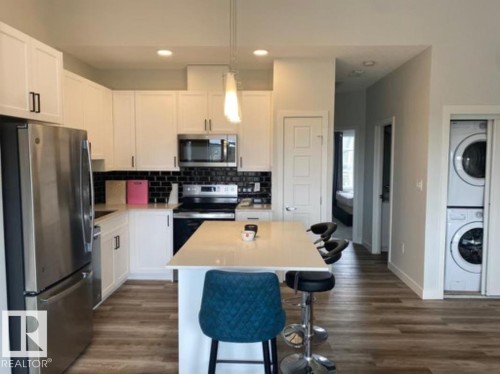 Modern kitchen with white cabinetry, stainless steel appliances, and a central island - #3 2905 141 St Sw, Edmonton, AB - Indoor Photo Showing Kitchen With Stainless Steel Kitchen