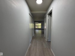 Hallway with wood-finish flooring and light gray walls - 