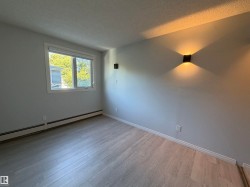 Wood-finish flooring, white trim, and wall-mounted sconces - 