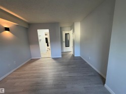Light gray walls, wood-finish flooring, accent wall sconce, white interior trim - 