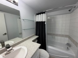 White tile bath surround, integrated bathtub, and vanity with an undermount sink - 