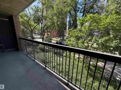 Balcony with concrete flooring and black metal railing, featuring a brick wall accent - 