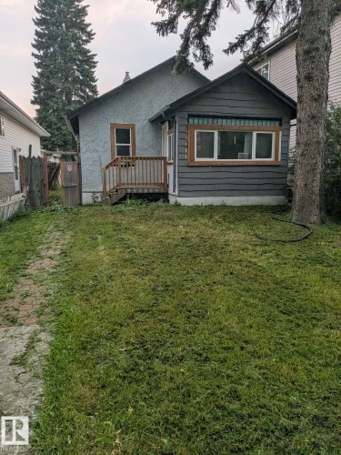 Property exterior featuring stucco siding, an enclosed porch with horizontal paneling, and a wood deck - 12722 116 Street Nw, Edmonton, AB - Outdoor