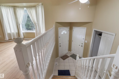 Bay window with a deep sill, wood-finish flooring, white banister with turned spindles, tile flooring, and a built-in closet with sliding doors - 1055 Jones Crescent Nw, Edmonton, AB - Indoor Photo Showing Other Room
