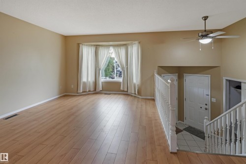 Wood-finish flooring, bay window, vaulted ceiling, and a ceiling fan with integrated lighting - 1055 Jones Crescent Nw, Edmonton, AB - Indoor Photo Showing Other Room
