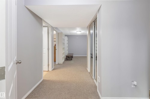 Bright hallway with neutral wall finishes, recessed ceiling lighting, and neutral-tone carpeting throughout - 1055 Jones Crescent Nw, Edmonton, AB - Indoor Photo Showing Other Room