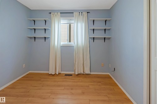 Wood-finish flooring with light blue wall paint - 1055 Jones Crescent Nw, Edmonton, AB - Indoor Photo Showing Other Room