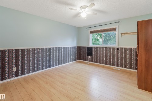 Wood-finish flooring, overhead ceiling fan with lighting, and a window with blinds - 1055 Jones Crescent Nw, Edmonton, AB - Indoor Photo Showing Other Room
