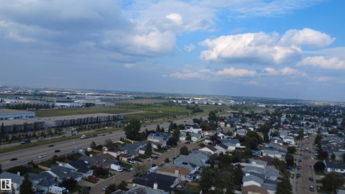 Residential neighborhood with multiple detached homes, bordered by an active highway and commercial/industrial structures - 1055 Jones Crescent Nw, Edmonton, AB - Outdoor With View