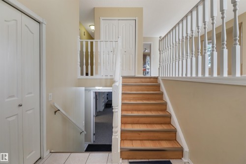 Staircase with wood-finish treads and white balusters - 1055 Jones Crescent Nw, Edmonton, AB - Indoor Photo Showing Other Room