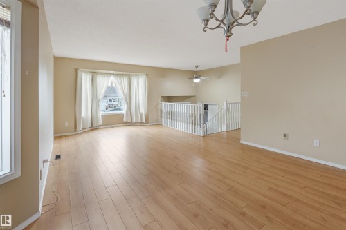 Spacious interior with wood-finish flooring, a bay window, and a chandelier - 1055 Jones Crescent Nw, Edmonton, AB - Indoor