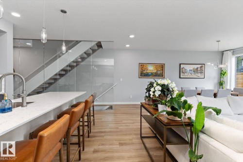 Integrated kitchen island with a white countertop and stainless steel sink - 3241 Kulay Way Sw, Edmonton, AB - Indoor