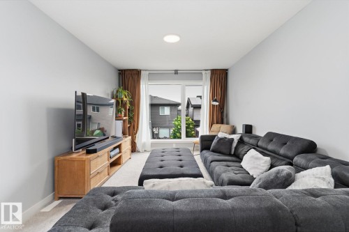 Recessed ceiling lighting, large window with natural light, light-toned walls, and carpeted flooring - 3241 Kulay Way Sw, Edmonton, AB - Indoor Photo Showing Living Room
