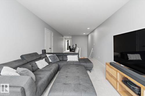 Recessed ceiling lighting, light gray wall paint, and light-colored carpet flooring - 3241 Kulay Way Sw, Edmonton, AB - Indoor Photo Showing Living Room