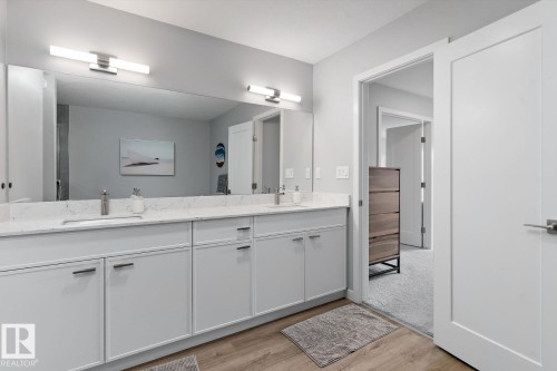 Dual vanity with white cabinetry, integrated sinks, and a large mirror - 3241 Kulay Way Sw, Edmonton, AB - Indoor Photo Showing Bathroom