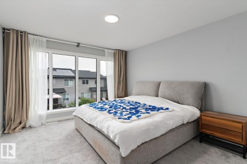 Floor-to-ceiling windows with layered drapes, recessed ceiling lighting, light gray wall paint, and gray carpet flooring - 3241 Kulay Way Sw, Edmonton, AB - Indoor Photo Showing Bedroom