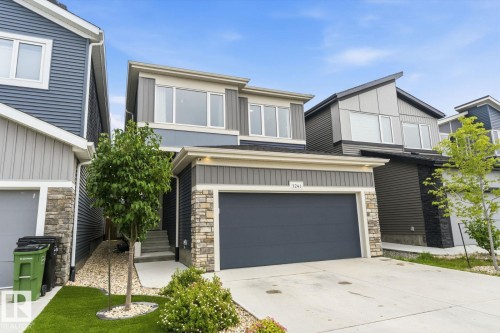 Modern exterior with horizontal siding, stone veneer accents, and an attached garage - 3241 Kulay Way Sw, Edmonton, AB - Outdoor